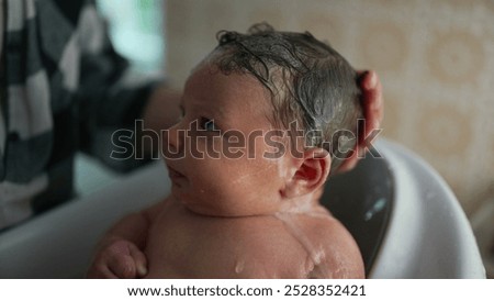 Similar – Newborn in the bathtub with her mother washing her hair