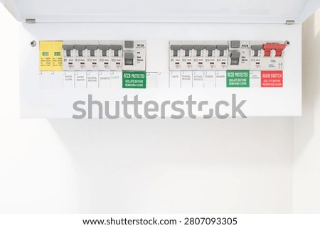 Close-up of a newly installed electrical distribution and safety panel showing individual circuit breakers and the red coloured mains electric cut off switch. Seen in a newly renovated apartment.