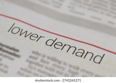 Close-Up of Newspaper Article Featuring Bold 'Lower Demand' Headline