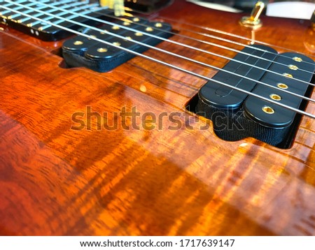 Closeup nickel stings and black pickup the orange guitar patterned wood Koa.