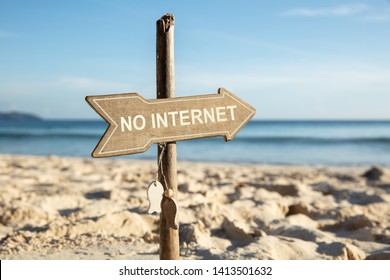 Close-up Of No Internet Wooden Directional Arrow Sign Pole On Sandy Beach