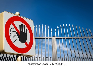 Closeup of a No Trespassing sign or Do Not Enter sign, and a closed gate (wrought iron gate with sharp points) of a private property against a clear blue sky with clouds and copy space.