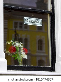 Close-up of a No Vacancies sign displayed in the window of an accommodation in the UK.