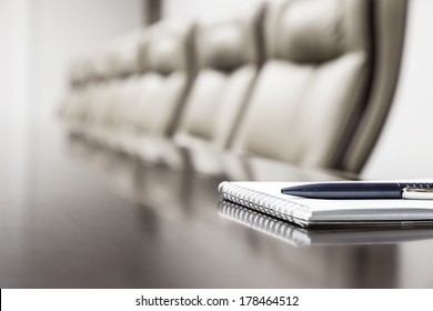 Closeup Of Notepad For Agenda Kept On Table In Empty Corporate Conference Room Before Business Meeting