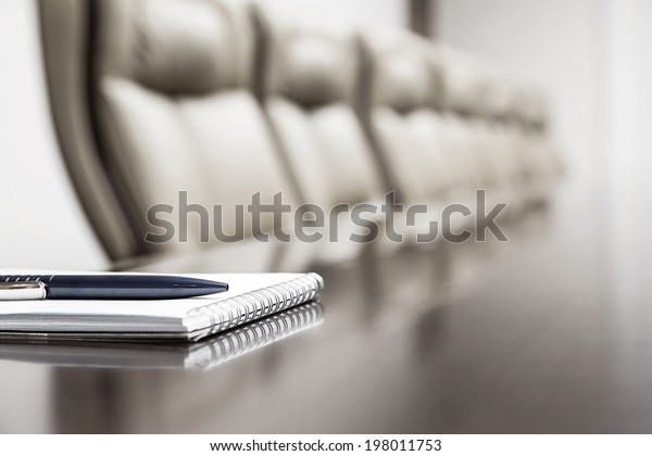 Closeup of notepad for\
agenda kept on table in empty corporate conference room before\
business meeting