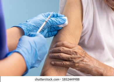 Closeup nurse doing vaccine injection to senior woman. - Powered by Shutterstock