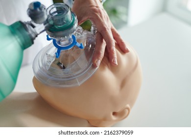 Close-up of nurse putting oxygen mask on face of mannequin and learning to use it during training - Shutterstock ID 2162379059