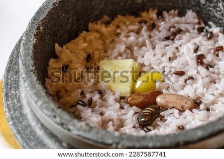 Close-up of Nutritious Hot Stone Pot Rice with black rice, ginkgo seed, bean and sweet potato on stone pot at restaurant, South Korea
