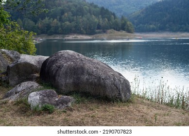 Closeup o big rocks  with trees in border the lake of Kruth-Wildenstein in France