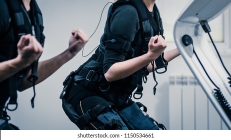 Closeup O Two Women Squatting During EMS Workout At Gym