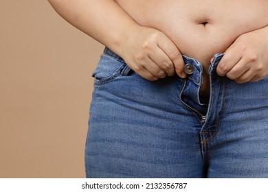Closeup of obese woman with overweighted stomach zipping up jeans. Sudden weight gain. Visceral fat. Body positive. Tight little clothes. Need for wardrobe change.