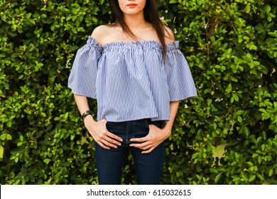 Close-up Off the Shoulder blue shirt and blue jeans on trees background