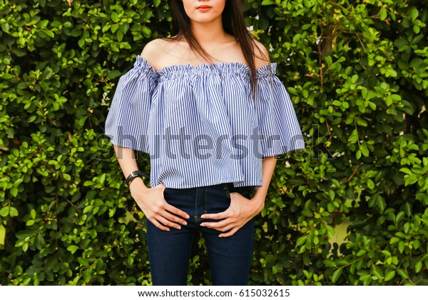 Close-up Off the Shoulder blue shirt and blue\
jeans on trees\
background