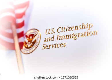 Closeup Of Official Letter From US Citizenship And Immigration Services For Becoming A Citizen In The United States After Going Through The Naturalization Process. Part Of American Flag In Background.