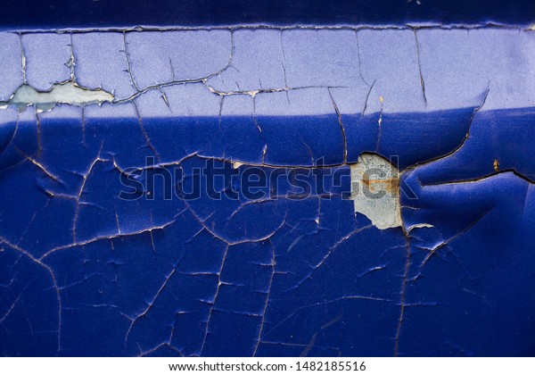 Close-up of old blue car\
paint broken, crack color of automobile.Car paint cracks, Cracked\
painted metal surface. Closeup of cracked and peeling paint on an\
old car.