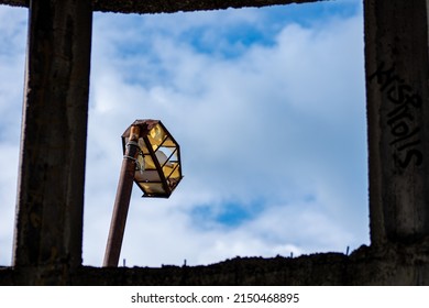 A Closeup Of An Old Broken Street Light Viewed From A Window Frame