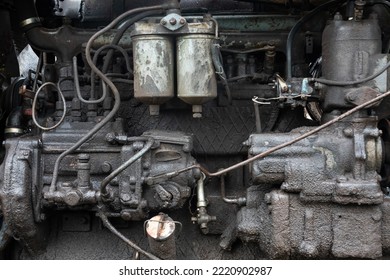 Close-up of an old diesel engine. The surface of the parts is covered with a thick layer of dirt and oil. There are signs of repair. Background. Texture.