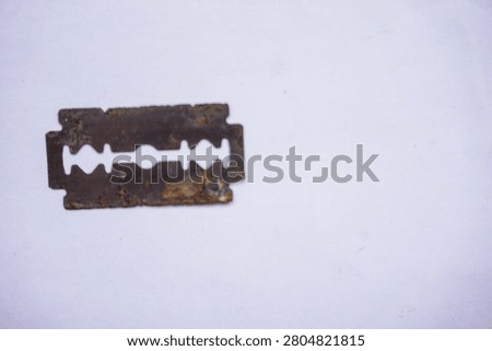 A close-up of an old double-edge razor blade that is very rusty, corroded, and dirty. A razor in this condition has lost its sharpness and is very dangerous to reuse. Health Risks of Rusty Razors