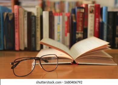 Close-up of old glasses on a reading table Open books and stack of books into the background selective focus and shallow depth of field