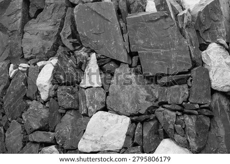 Close-up of old gritty stone structure in greyscale.