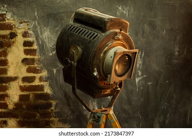 Close-up Of An Old Grunge Spotlight: A Light Source For Photos, Videos And Movies In The Studio On A Brick Loft-style Background On Stand. High Quality Photo.