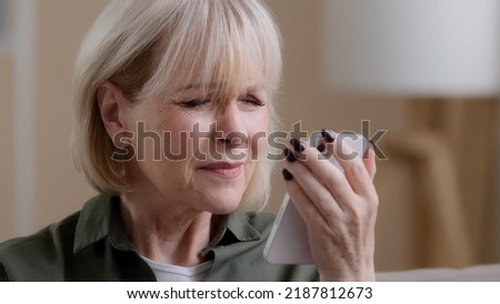 Close-up old lady mature aged female grandmother Caucasian retired woman looking at phone screen vision problems poor eyesight trying to read news disease eyes damage needs glasses or laser