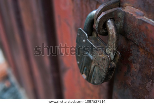 Closeup of old lock on red metal door. Old iron\
lock on the door.