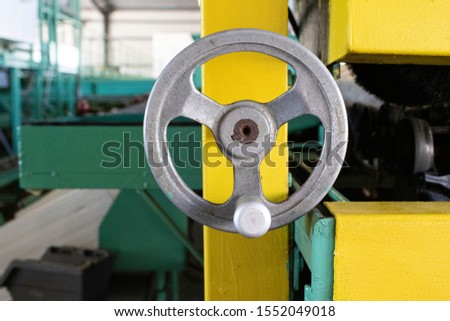 Closeup of old, metal, mechanical crank inside factory building