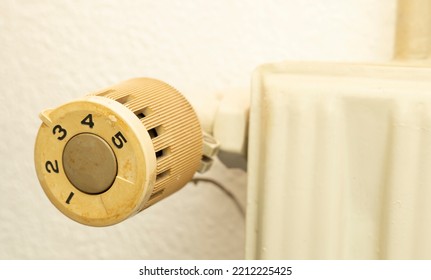 Closeup Of Old Radiator Heating In House With White Wall Background.  Knob With Number To Be Adjust And Control Temperature In Room In Winter, Energy Bill Expenses Household