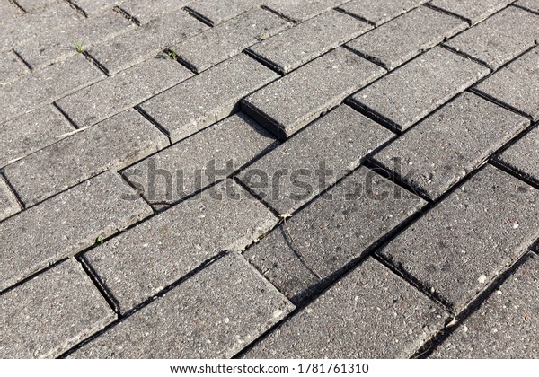 close-up of an old road made of modern tiles made of\
cement and other materials, a road for pedestrians and transport,\
different cars