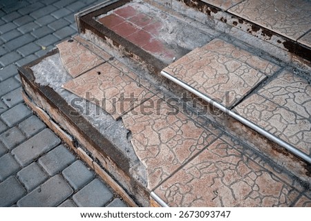 A close-up of old, run down, tiled stairs of a house with broken, missing, slipped tiles that needs repairing and renovation. High quality photo