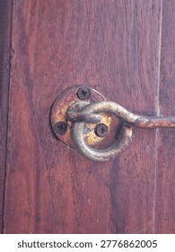 Closeup of an old and rustic cabin hook and eye latch on a wooden door