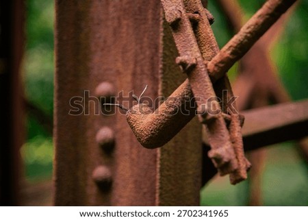 Closeup of an old rusty bracket with nuts and bolts holding conduit in place with cut wires protruding form the conduit opening at the Nuttalburg Tipple in New River Gorge National park.