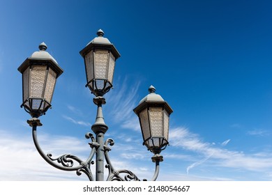 Close-up Of Old Street Lamp Posts Against A Clear Blue Sky With Clouds And Copy Space. Loggia Town Square (Piazza Della Loggia), Brescia Downtown, Lombardy, Italy, Southern Europe.