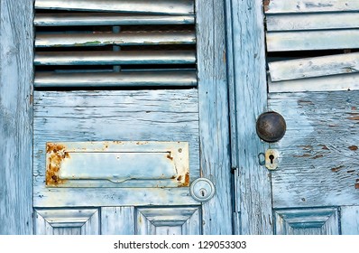 Closeup Of Old Weathered Doors With Mail Slot, Shutters, Door Knob And Keyhole Located In New Orleans French Quarter - Powered by Shutterstock