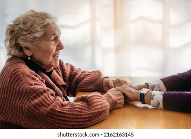 Close-up Of An Old Woman Holding Another Woman's Hands And Smiling. Only One Person Is Seen. Concept Of Care And Affection In Old Age. Nursing Home.