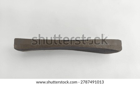 Close-up of an old worn concave whetstone sharpening stone for kitchen knives or blades, isolated on a white background.