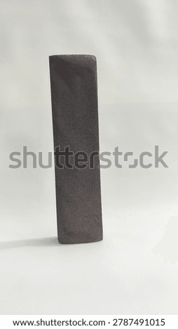 Close-up of an old worn concave whetstone sharpening stone for kitchen knives or blades, isolated on a white background.