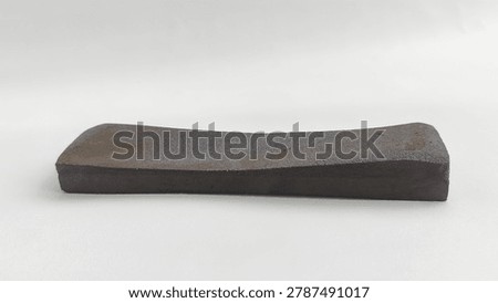 Close-up of an old worn concave whetstone sharpening stone for kitchen knives or blades, isolated on a white background.