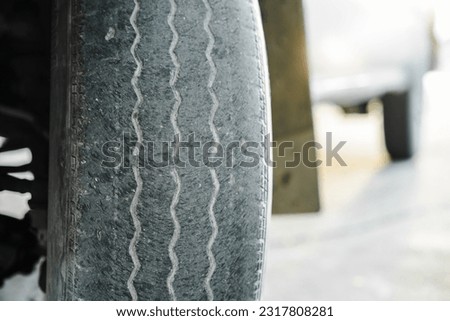 Close-up of an old worn tire or a bald tire not in good condition. The front tires are worn and bald from long use. The concept of tire wear and the dangers of using old tires. car tires