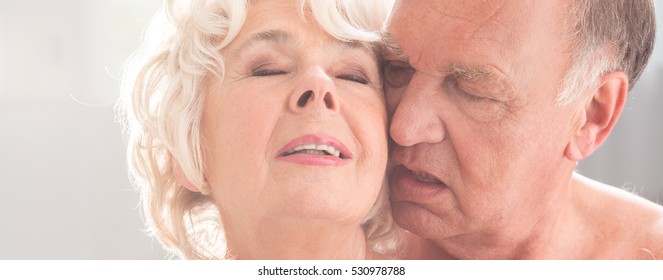 Close-up Of Older People Faces In Ecstasy While Touching And Kissing