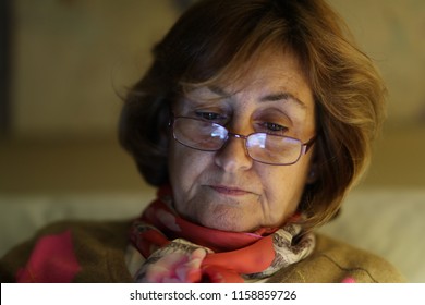 Close-up Of Older Woman Reading , Seated On Living-room Sofa