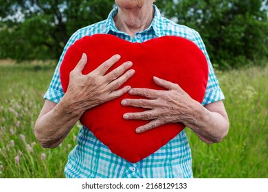 Close-up Of Older Womans Hand Holding Red Fluffy Heart