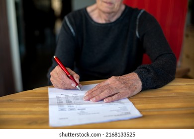 Nahaufnahme einer älteren Frau bei der Unterzeichnung eines Papiers