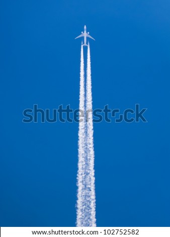 Closeup on airplane contrail against clear blue sky