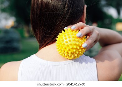 Close-up On Back Of Young Woman Doing Neck And Shoulder Massage With Spiky Rubber Ball, Relaxing Tense Neck Muscles. 