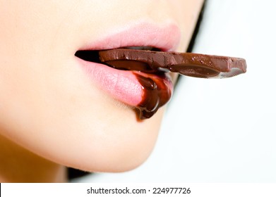 Closeup On Beautiful Passionate Woman Eating Chocolate Which Flows Down On Her Lips On The White Background