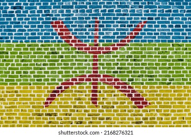 Close-up on a brick wall with the flag of Berber painted on it.
