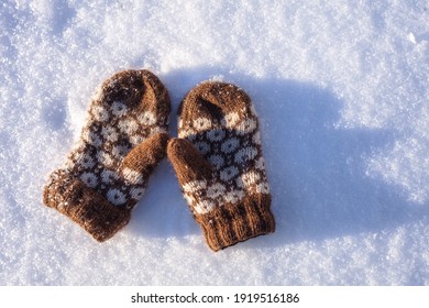 Closeup On Brown Mittens On White Snow