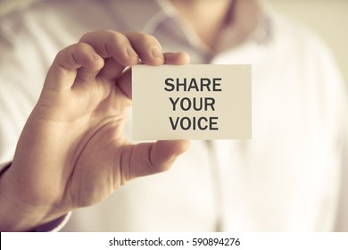 Closeup On Businessman Holding A Card With Text SHARE YOUR VOICE, Business Concept Image With Soft Focus Background And Vintage Tone